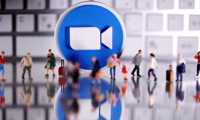 A 3D printed Zoom logo is placed between small toy people figures and a keyboard in this illustration taken on April 12, 2020. (Dado Ruvic/Reuters, Illustration) 