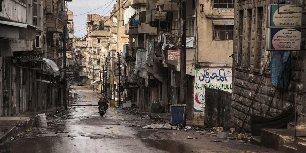 People ride a motorcycle along a street in a deserted area in the town of Ariha, about 13 kilometres south of Idlib in the northwestern Syrian Idlib province on Feb. 7, 2020, (Aaref Watad/AFP via Getty Images)