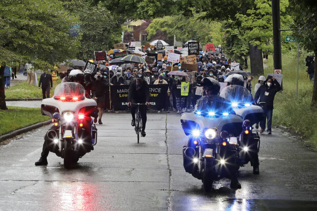Police on motorcycles ride ahed of protesters organized by Black Lives Matter Seattle-King County, in Seattle, June 12, 2020. (AP Photo/Ted S. Warren)