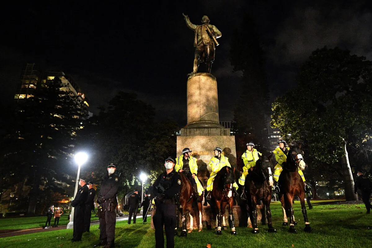 Police stand guard at the statue of Captain Cook in Hyde Park during a protest rally against Aboriginal deaths in custody and to show solidarity with Black Lives Matter movement, in Sydney on June 12, 2020. (Saeed Khan/AFP via Getty Images)