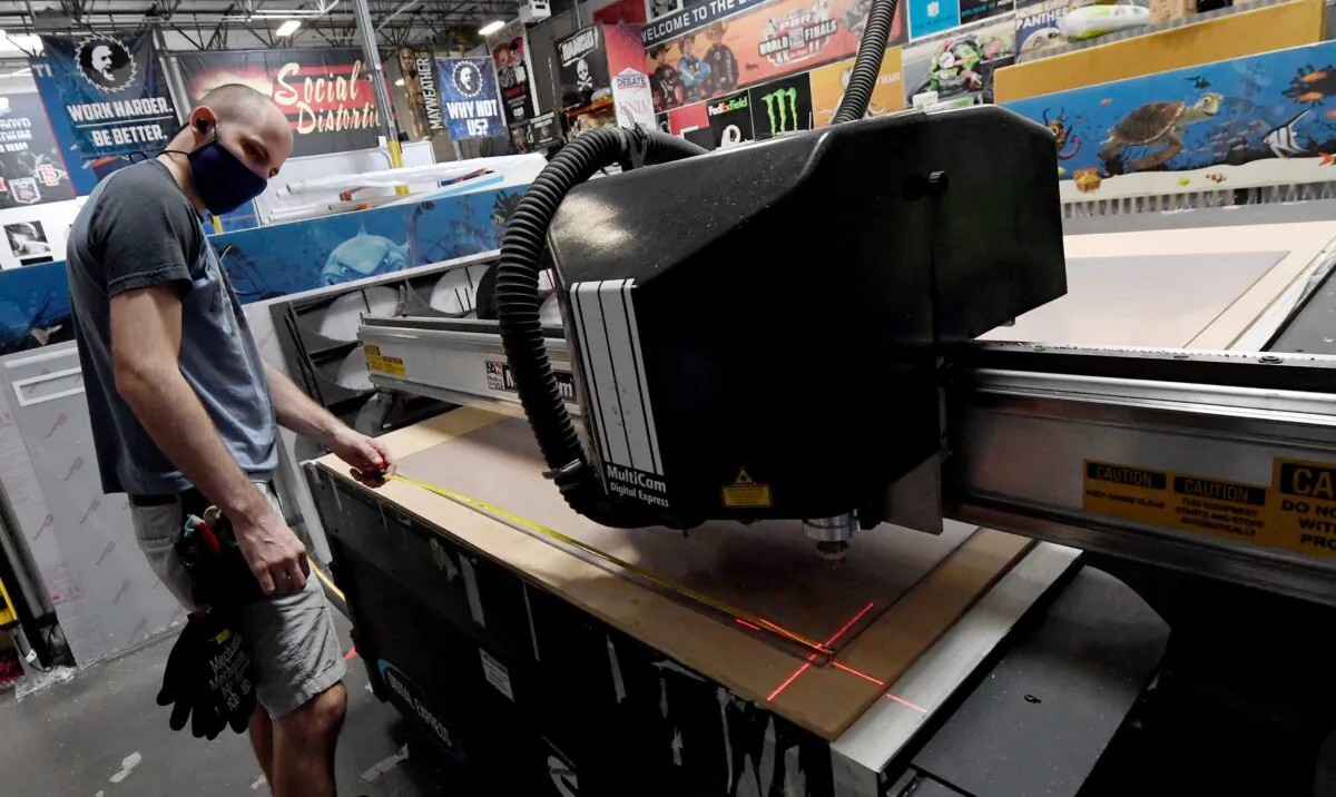 Jaeden Milam makes clear acrylic safety shield dividers at Screaming Images in Las Vegas, Nev., on May 18, 2020. The Las Vegas company usually works on large-scale graphic designs and installations for customers like Las Vegas resorts. After the COVID-19 pandemic shut down nonessential businesses, they designed and began manufacturing recyclable, clear acrylic safety shield dividers for various table games and slot machines to help protect employees and customers once hotel-casinos in the state are allowed to reopen. (Ethan Miller/Getty Images)