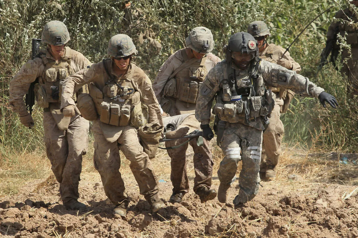 U.S. Army flight medic SGT Tyrone Jordan (front R) of Charlotte, NC of Dustoff Task Force Shadow of the 101st Combat Aviation Brigade helps Marines carry a wounded Afghani man to a MEDEVAC helicopter Sept. 29, 2010 near Marja, Afghanistan.  (Scott Olson/Getty Images)