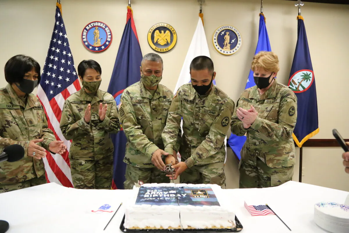In celebration of the Army's 245th birthday, the Guam Army National Guard's oldest Soldier Col. Mike Cruz, left, and youngest Soldier Pvt. Jayton Penaflor cut the birthday cake during a ceremony at the Guam National Guard Headquarters in Barrigada June 12. (JoAnna Delfin/U.S. Army National Guard)