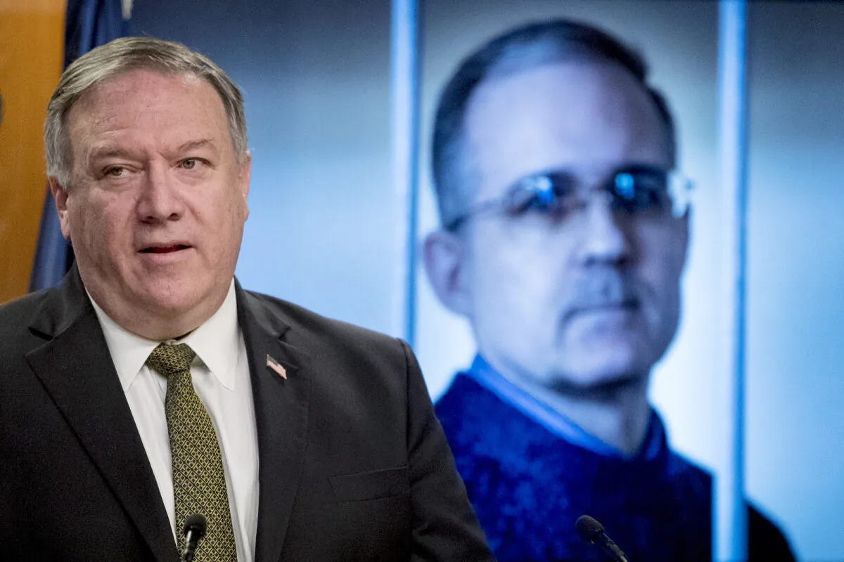 An image of Paul Whelan, a former U.S. Marine who was arrested for alleged spying in Moscow, is displayed behind Secretary of State Mike Pompeo, at a news conference at the State Department in Washington, on June 10, 2020. (AP Photo/Andrew Harnik, Pool)