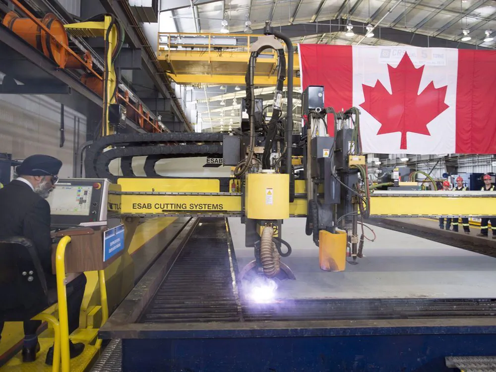 Defence Minister Harjit Sajjan (L) participates in a steel cutting ceremony at the Seaspan Shipyards in North Vancouver, B.C. on June, 15, 2018.  (Jonathan Hayward/The Canadian Press)