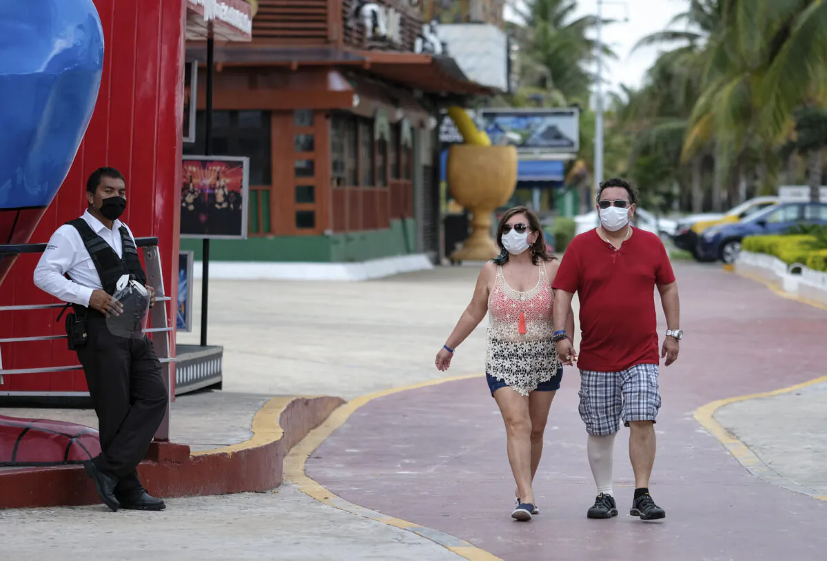 Tourists walk past restaurants and shops along an empty sidewalk in Cancun, Mexico, on June 13, 2020. (Victor Ruiz/AP)