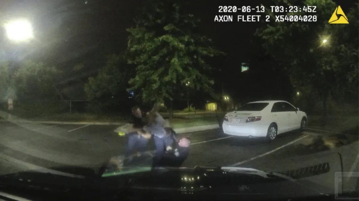A dashboard camera shows Rayshard Brooks (C) struggling with officers Garrett Rolfe (L) and Devin Brosnan (R) in the parking lot of a Wendy's restaurant, in Atlanta, Ga., on June 13, 2020. (Atlanta Police Department via AP)