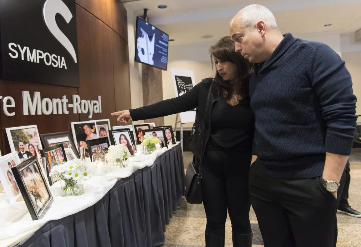 People pause at a memorial prior to a ceremony to remember those who lost their lives in Ukraine International Airlines Flight 752, in Montreal, Canada, on Jan. 19, 2020. (Graham Hughes/The Canadian Press)