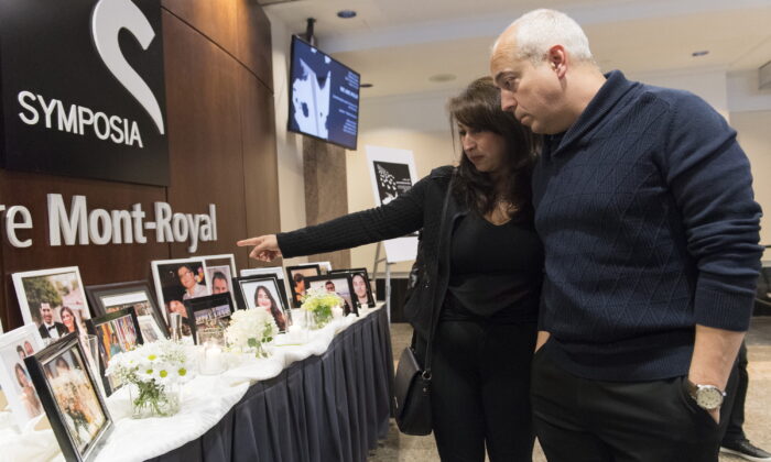 People pause at a memorial prior to a ceremony to remember those who lost their lives in Ukraine International Airlines Flight 752, in Montreal, Canada, on Jan. 19, 2020. (Graham Hughes/The Canadian Press)