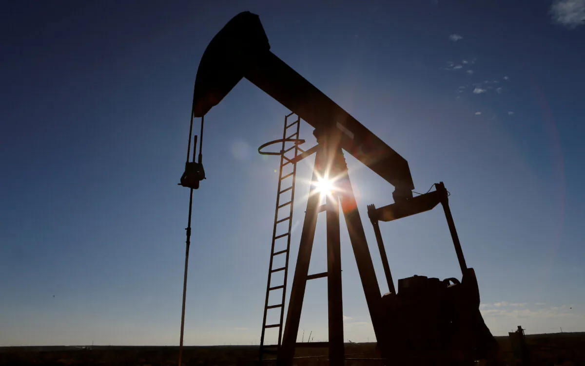 The sun is seen behind a crude oil pump jack in the Permian Basin in Loving County, Texas on November 22, 2019. (Angus Mordant/Reuters) 