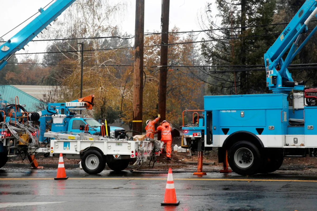 PG&E works on power lines to repair damage caused by the Camp Fire in Paradise, Calif., on Nov. 21, 2018. (Elijah Nouvelage/Reuters)