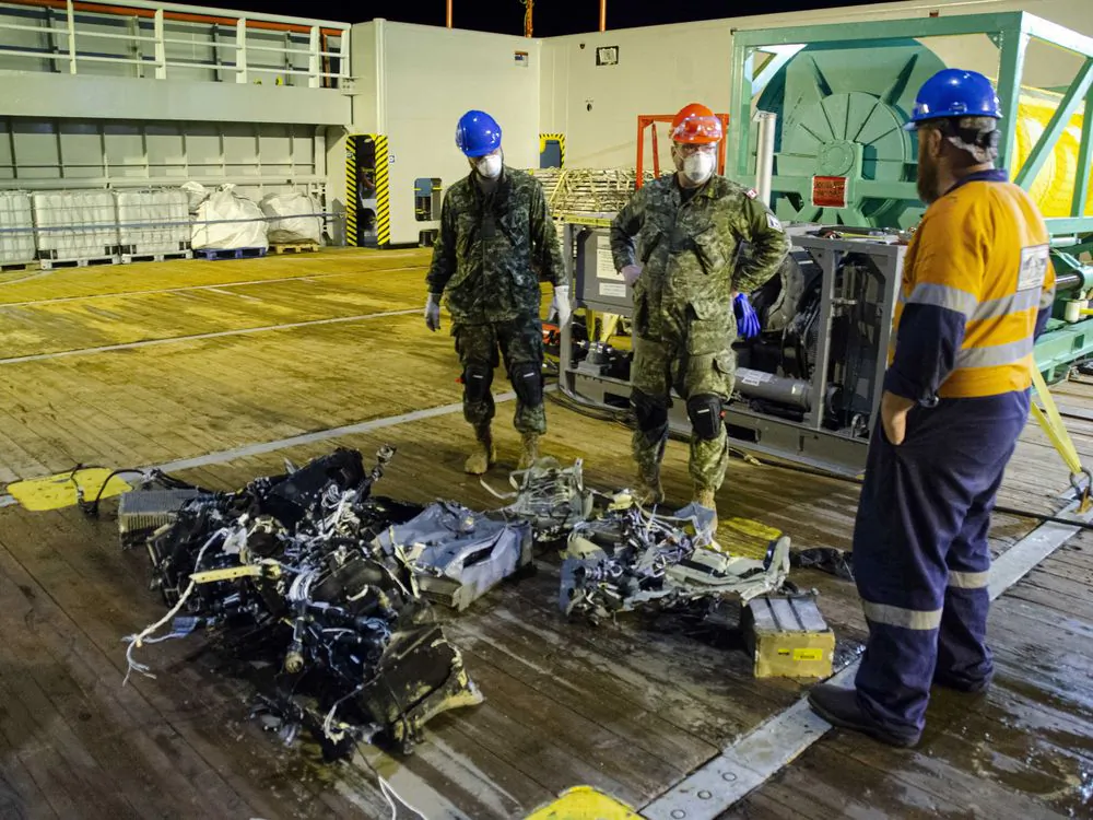 CF members and EDT Hercules personnel inspect recovered parts of the helicopter Stalker 22 during recovery operations for the aircraft in the Mediterranean Sea on May 31, 2020. (Cdr Robert Watt/THE CANADIAN PRESS/HO-Department of National Defence)