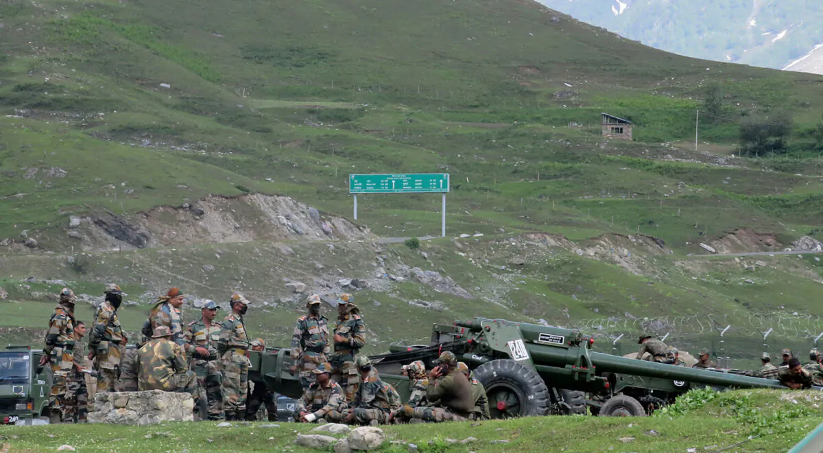 Indian army soldiers rest next to artillery guns at a makeshift transit camp before heading to Ladakh, near Baltal, southeast of Srinagar, on June 16, 2020. (Stringer/Reuters)