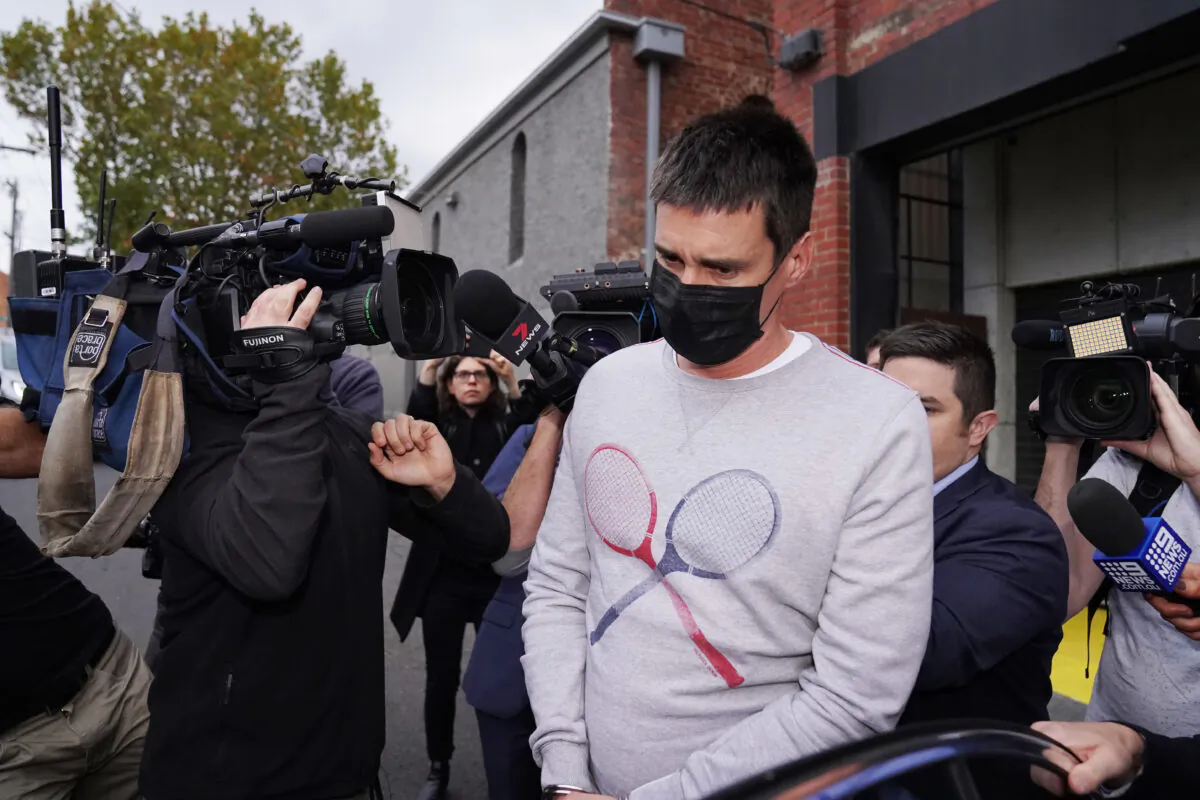 Richard Pusey, the driver of a Porsche who allegedly fled the scene of a truck crash on Melbourne's Eastern Freeway which killed four police officers, is taken away from his Fitzroy property by police in Melbourne, Australia, on April 23, 2020. (AAP Image/Michael Dodge)
