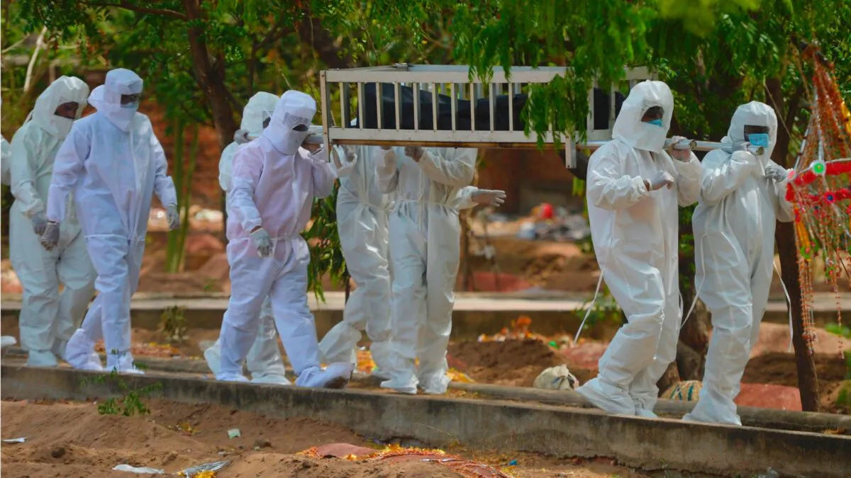 Volunteers from the Social Democratic Party of India carry an abandoned body of a victim who died from the CCP virus during a burial at a graveyard in Chennai, India, on June 16, 2020. (Arun Sankar/AFP via Getty Images) 