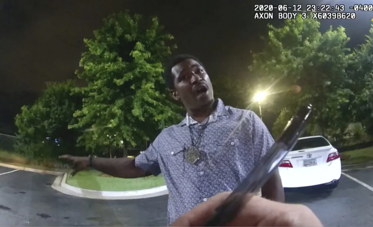 Rayshard Brooks speaking with police officer Garrett Rolfe as Rolfe writes notes during a field sobriety test in the parking lot of a Wendy's restaurant, in Atlanta, Georgia, on June 12, 2020. (Atlanta Police Department via AP)