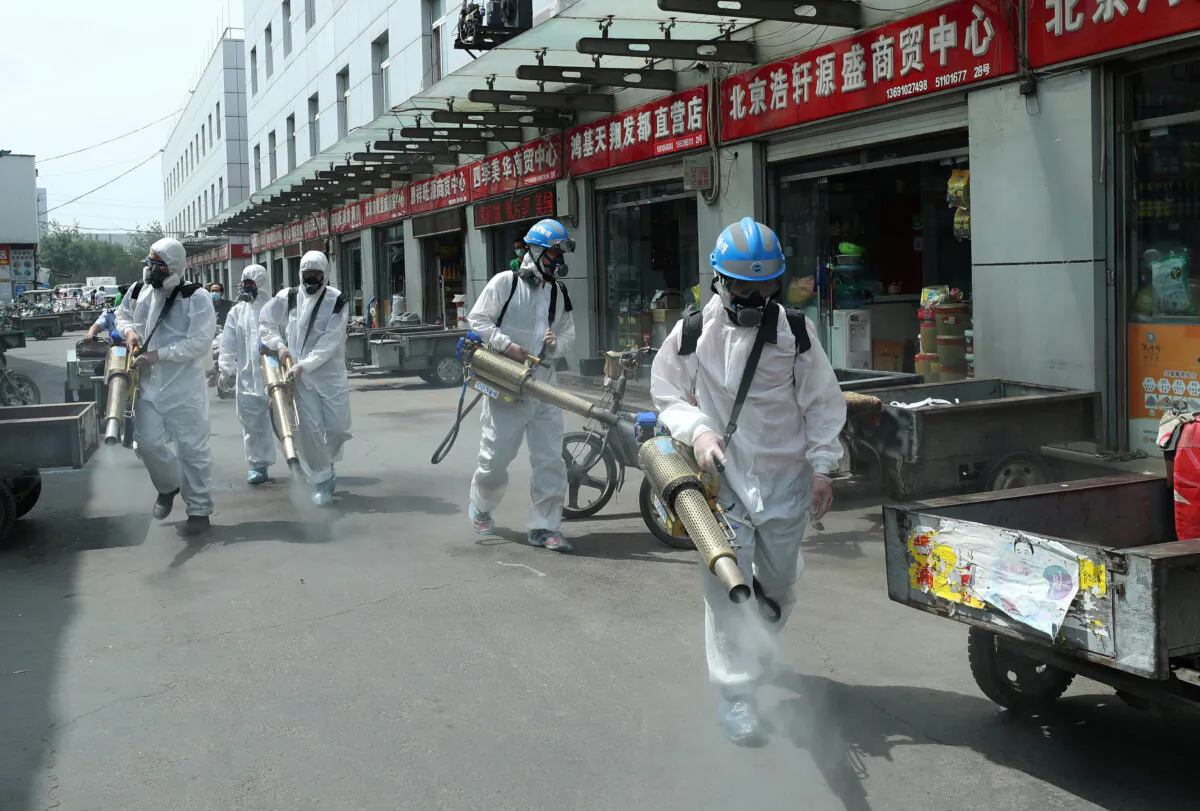 Volunteers from Blue Sky Rescue team in protective suits disinfect the Yuegezhuang wholesale market, following new cases of COVID-19 in Beijing on June 16, 2020. (China Daily via Reuters)