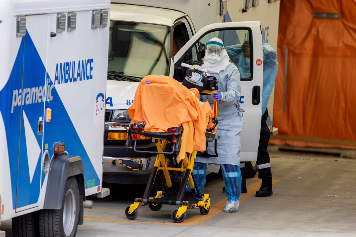 A paramedic transports a patient to Mount Sinai Hospital in Toronto on April 17, 2020.  The government commissioned mobile health units to increase hospital capacity. (Carlos Osorio/Reuters)