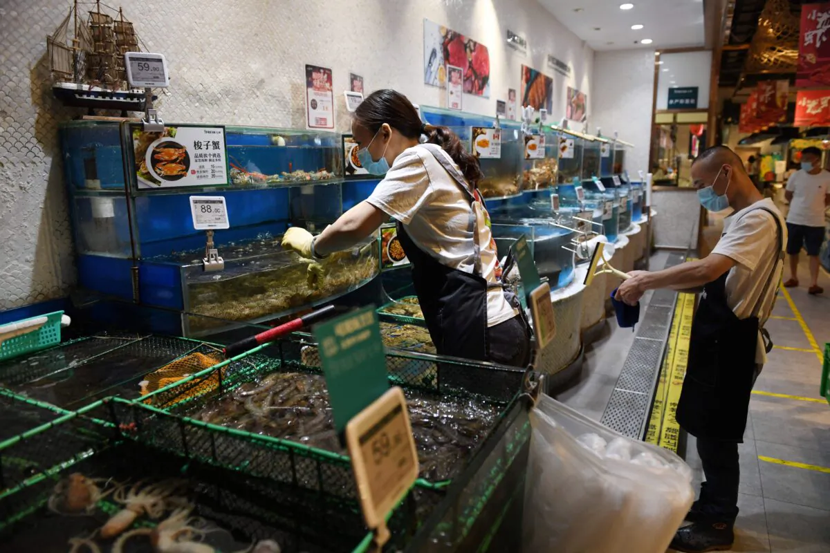 A worker is seen in the seafood section of a supermarket in Beijing, China, on June 17, 2020. (Greg Baker/AFP via Getty Images)