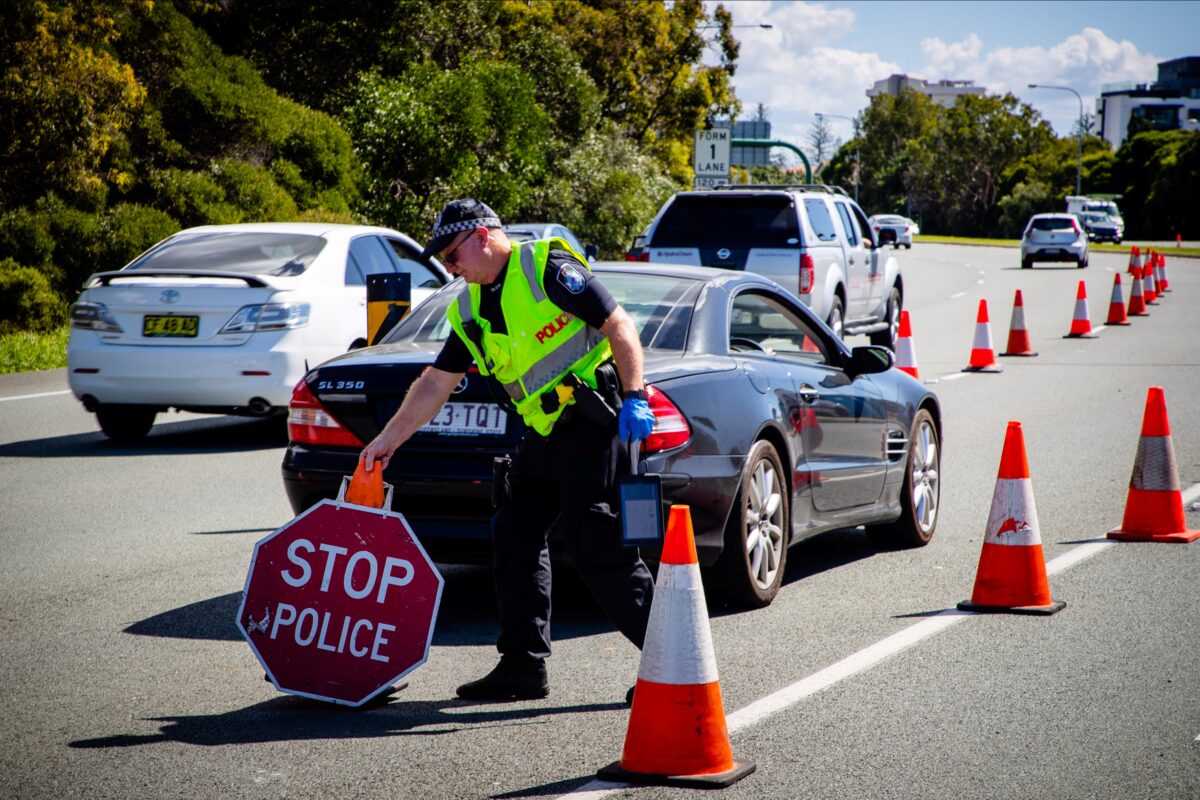 sign police queensland border stop checkpoint moves officer vehicle highway pacific south crossing wales brisbane getty