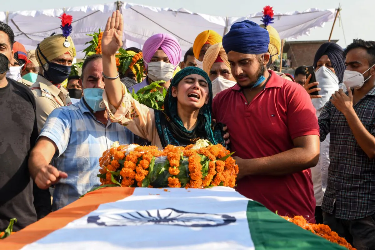 Sandeep Kaur (C) and her brother Prabhjot Singh (2R) react after laying the wreaths of flowers on the coffin of their father and soldier Satnam Singh who was killed in a recent clash with Chinese forces in the Galwan valley area, during the cremation ceremony at Bhojraj village near Gurdaspur on June 18, 2020. (Narinder Nanu/AFP/Getty Images)
