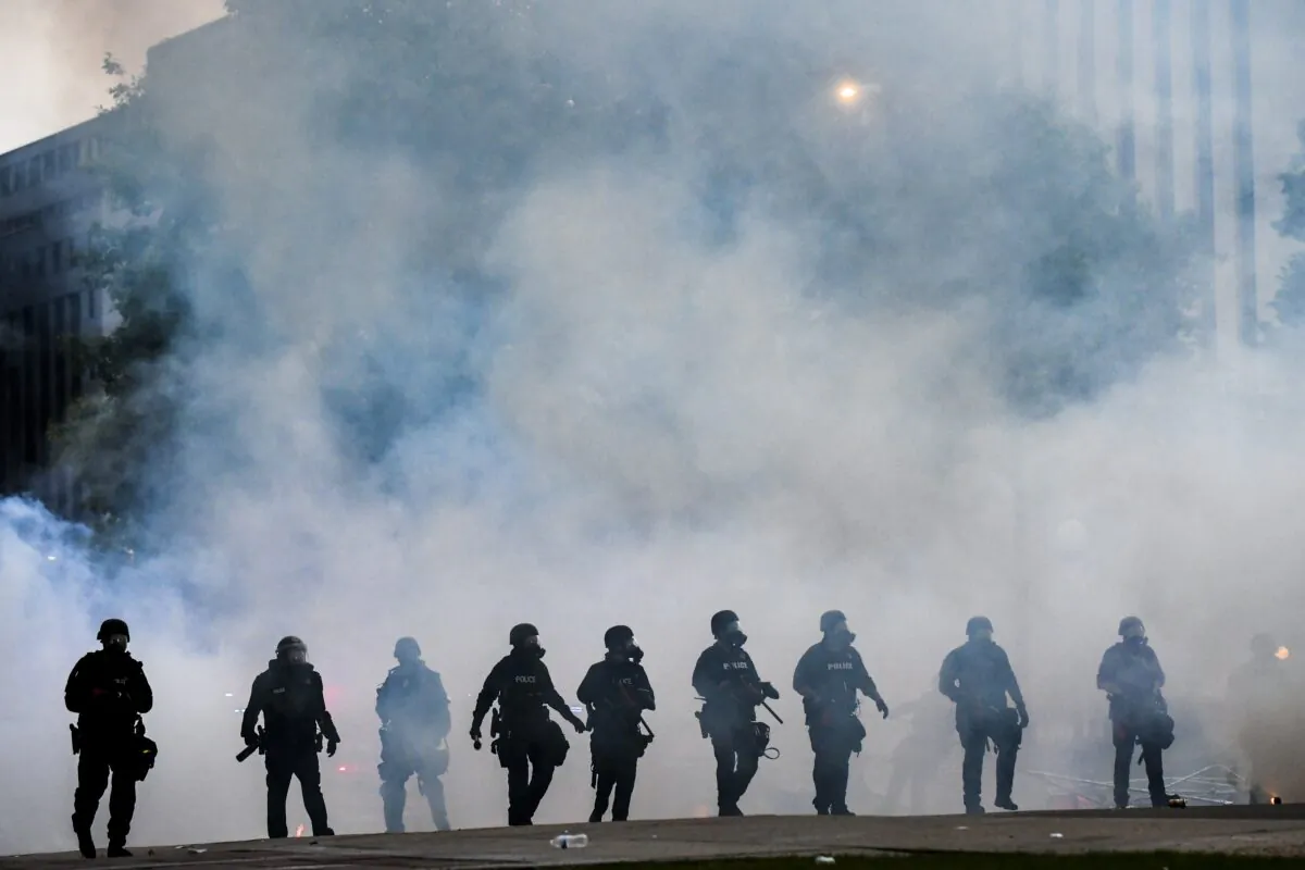 Police officers walk through a cloud of tear gas as they try to disperse people protesting against the death of George Floyd in front of the Colorado State Capitol, in Denver, Colo., on May 30, 2020, amid nationwide protests and riots. (Michael Ciaglo/Getty Images)
