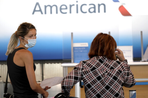 Travelers wait at the American Airlines ticket counter