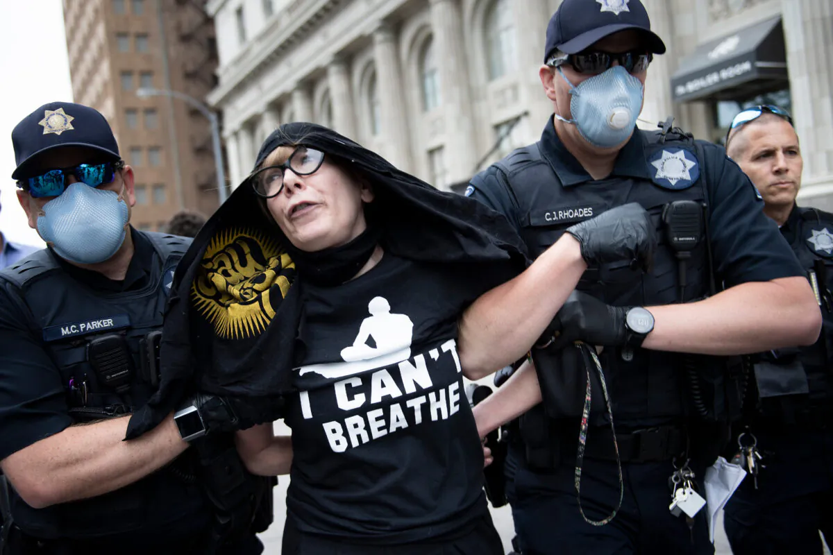 Tulsa Police take protester Sheila Buck into custody near an entrance to a security checkpoint for a rally with President Donald Trump at the BOK Center in Tulsa, Oklahoma, on June 20, 2020. (Brendan Smialowski/AFP/Getty Images)