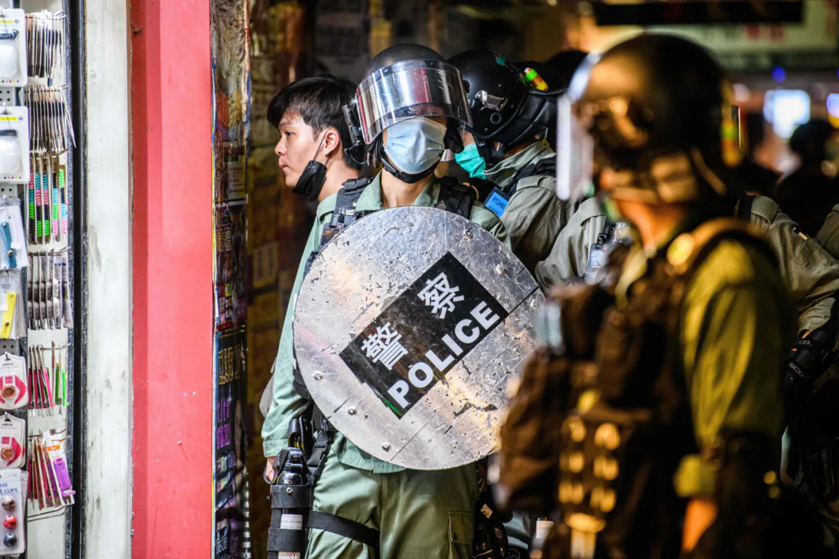 Police detain a man (L) as pro-democracy protesters gather in the Causeway Bay district of Hong Kong on June 12, 2020. (Anthony Wallace/AFP via Getty Images)