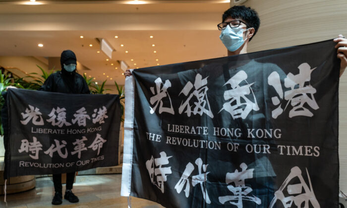 Pro-democracy supporters hold banners and shout slogans as they gather in a shopping mall during a lunch protest in Hong Kong on June 12, 2020. (Anthony Kwan/Getty Images)