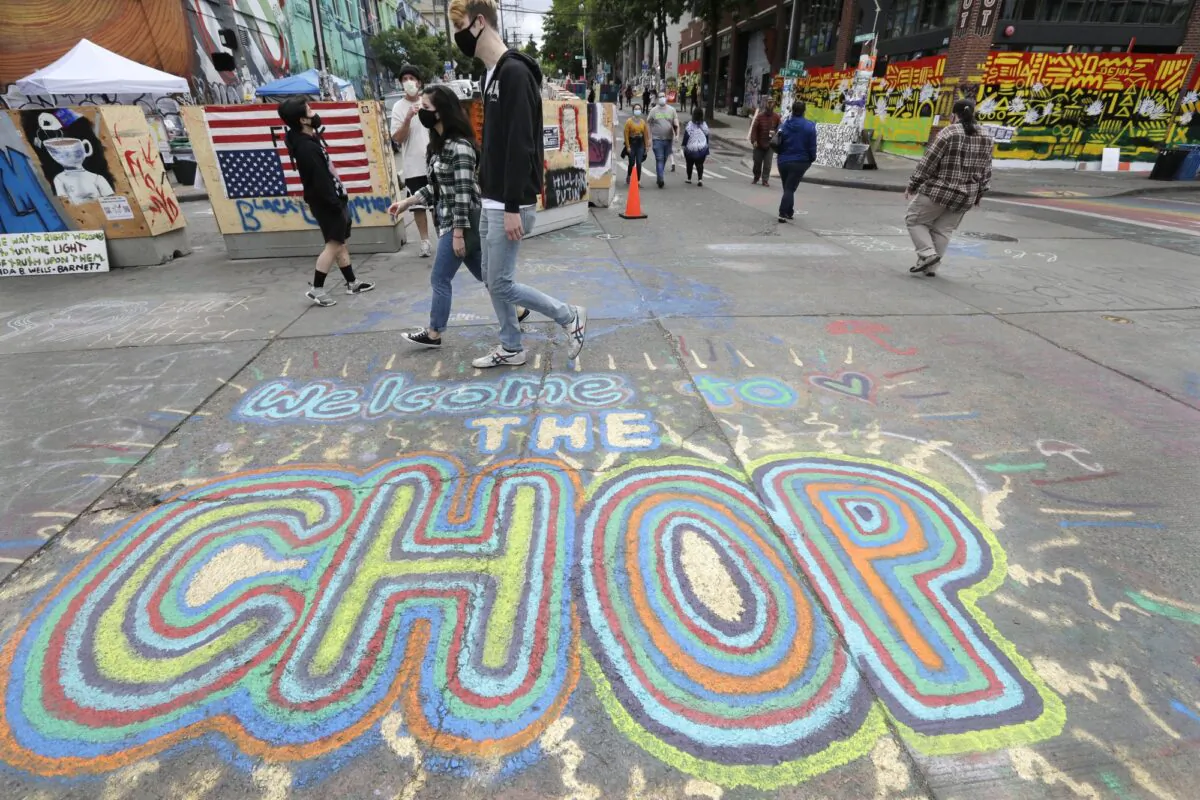 Pedestrians walk where streets are blocked off in what has been named the Capitol Hill Occupied Protest (CHOP) zone in Seattle, on June 21, 2020.  (Elaine Thompson/AP Photo)