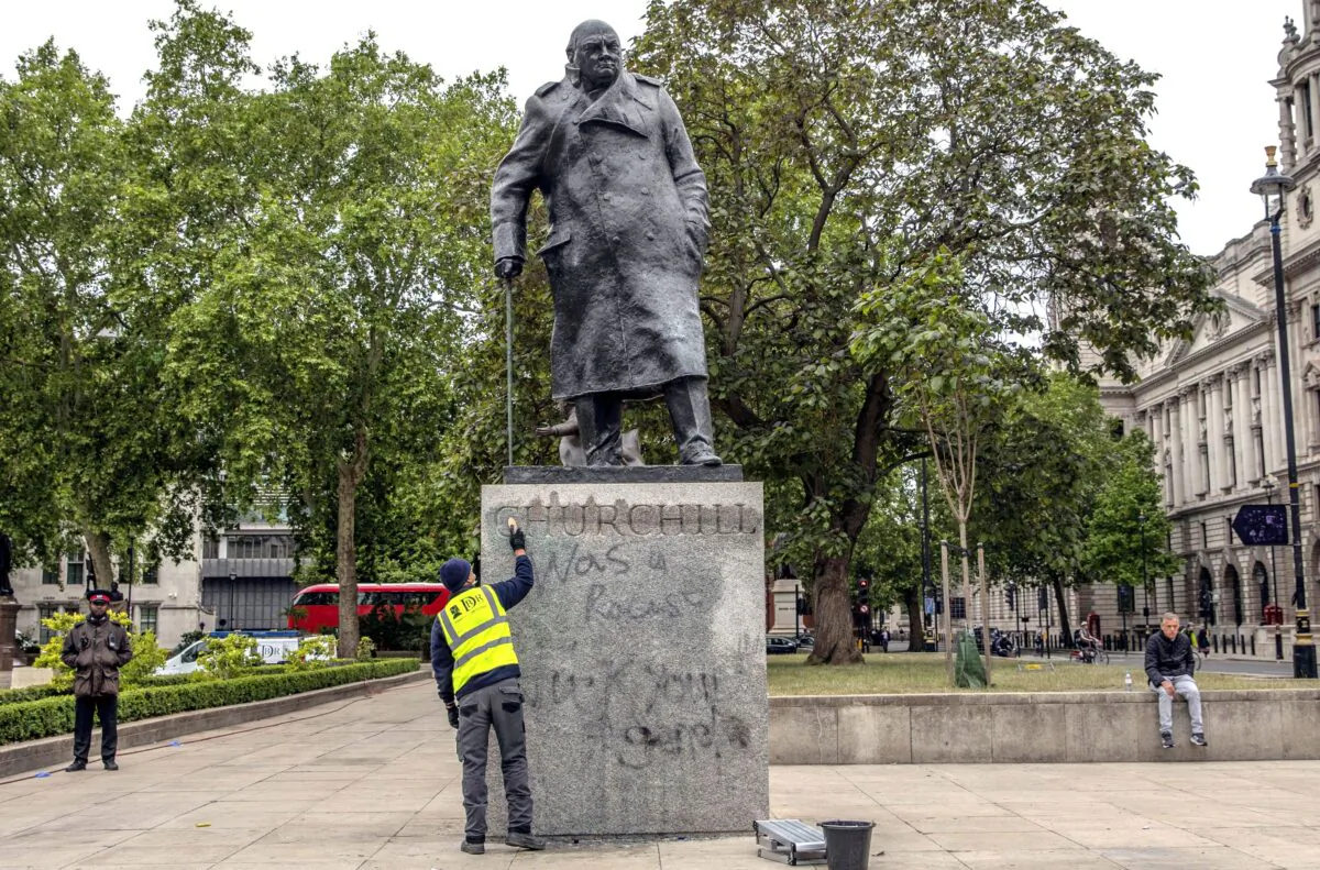 A worker cleans the statue of former prime minister Winston Churchill that was spray-painted with graffiti during a Black Lives Matter protest in Parliament Square, London, on June 8, 2020. (Dan Kitwood/Getty Images)