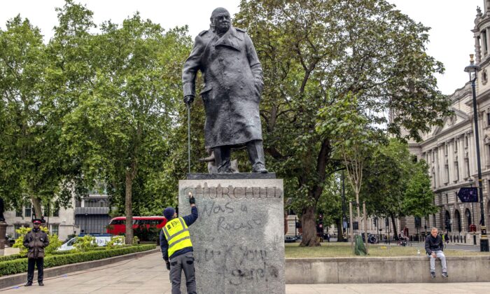 A worker cleans the statue of former prime minister Winston Churchill that was spray-painted with graffiti during a Black Lives Matter protest in Parliament Square, London, on June 8, 2020. (Dan Kitwood/Getty Images)