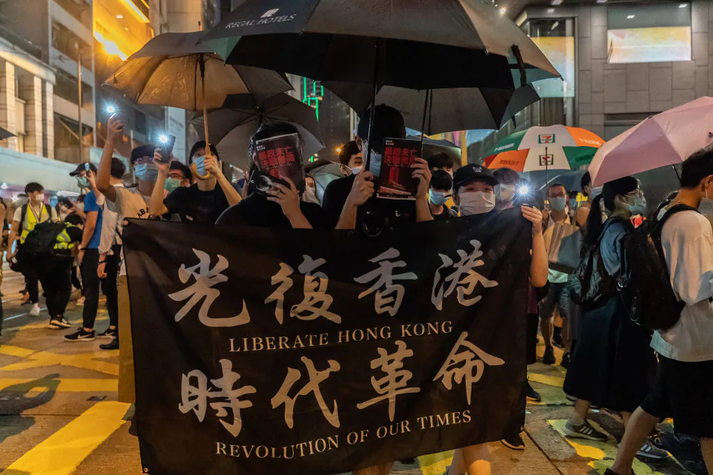 Protesters hold a banner as they march on a street during a rally in Central district in Hong Kong on June 9, 2020. (Anthony Kwan/Getty Images)