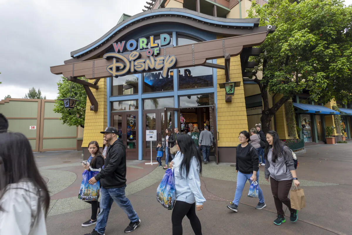 People walk near the World of Disney store in the Downtown Disney District shopping mall in Anaheim, Calif., on March 14, 2020. (David McNew/AFP via Getty Images)