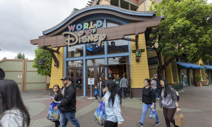 People walk near the World of Disney store in the Downtown Disney District shopping mall in Anaheim, Calif., on March 14, 2020. (David McNew/AFP via Getty Images)