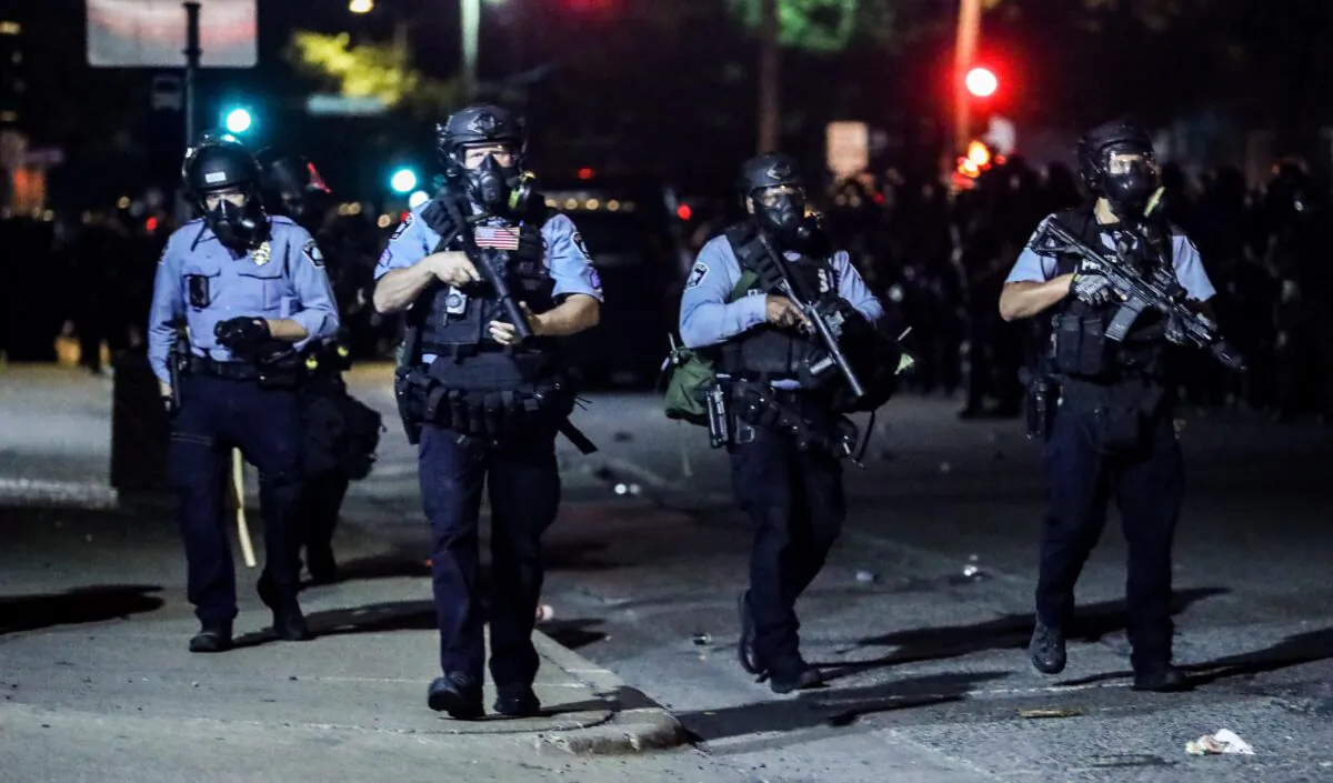 Police take back the streets at around midnight after firing copious amounts of tear gas to disperse protesters and rioters outside the Minneapolis Police 5th Precinct during the fourth night of protests and violence following the death of George Floyd, in Minneapolis, Minn., on May 29, 2020. (Charlotte Cuthbertson/The Epoch Times)