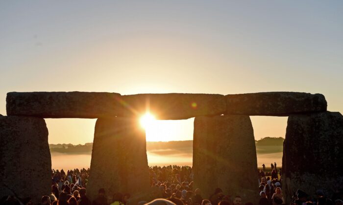 Visitors celebrate summer solstice and the dawn of the longest day of the year at Stonehenge in Amesbury, England, on June 21, 2019. (Finnbarr Webster/Getty Images)