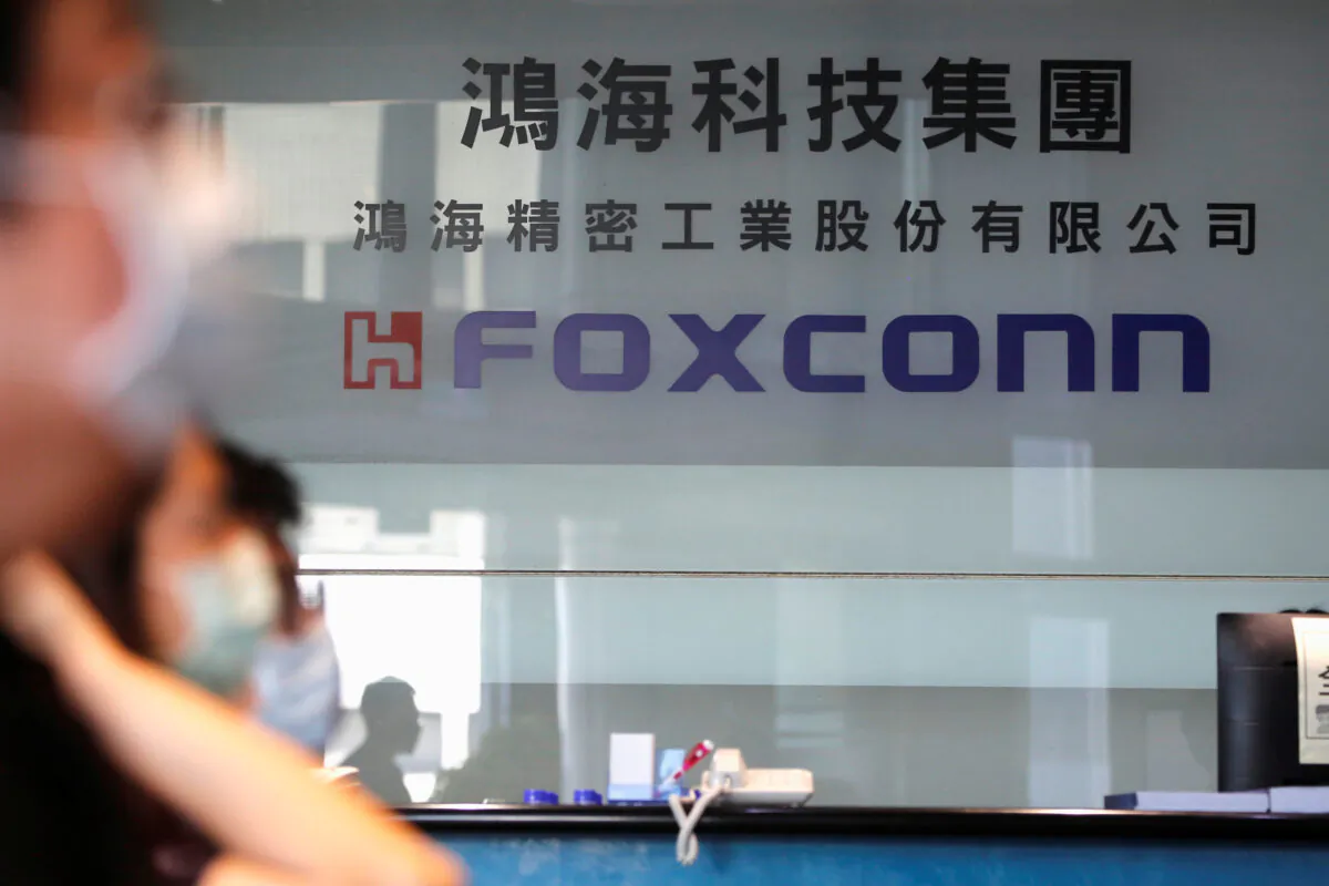 People wear masks to protect themselves from COVID-19, while listening to the annual general meeting at the lobby of Foxconn's office in Taipei, Taiwan on June 23, 2020. (Ann Wang/Reuters)