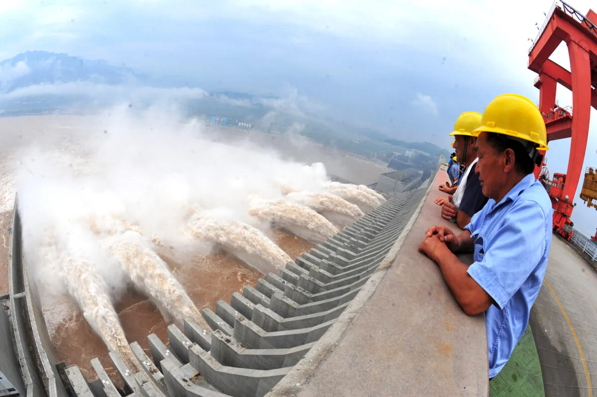Workers watch as water is released from the Three Gorges Dam, a gigantic hydropower project on the Yangtze river in Yichang in central China's Hubei province on July 24, 2012. (STR/AFP/GettyImages)