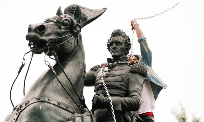 A vandal wraps chains around the neck of the statue of former President Andrew Jackson during an attempt by protesters to pull the statue down in the middle of Lafayette Park in front of the White House during racial inequality protests in Washington, on June 22, 2020. (Joshua Roberts/Reuters)