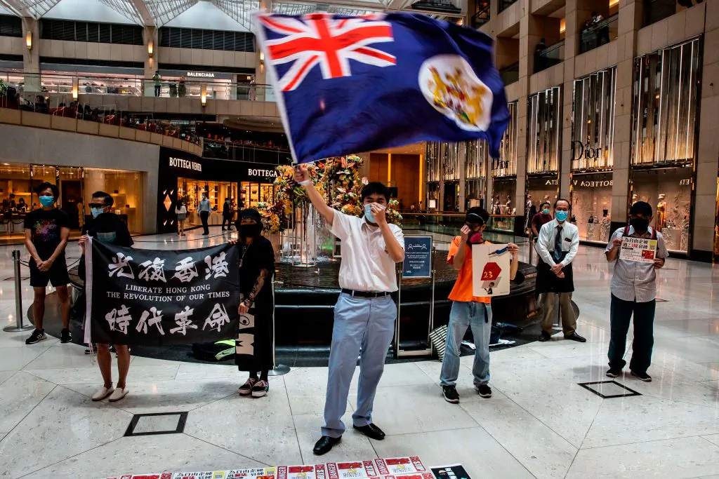 A pro-democracy protester waves a British colonial flag during a "Lunch With You" rally at a shopping mall in the Central district in Hong Kong on June 1, 2020. (Issac Lawrence/AFP via Getty Images)