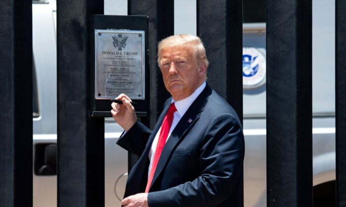 President Donald Trump looks on before signing a plaque as he participates in a ceremony commemorating the 200th mile of border wall at the international border with Mexico in San Luis, Ariz., on June 23, 2020. (Saul Loeb/AFP via Getty Images)