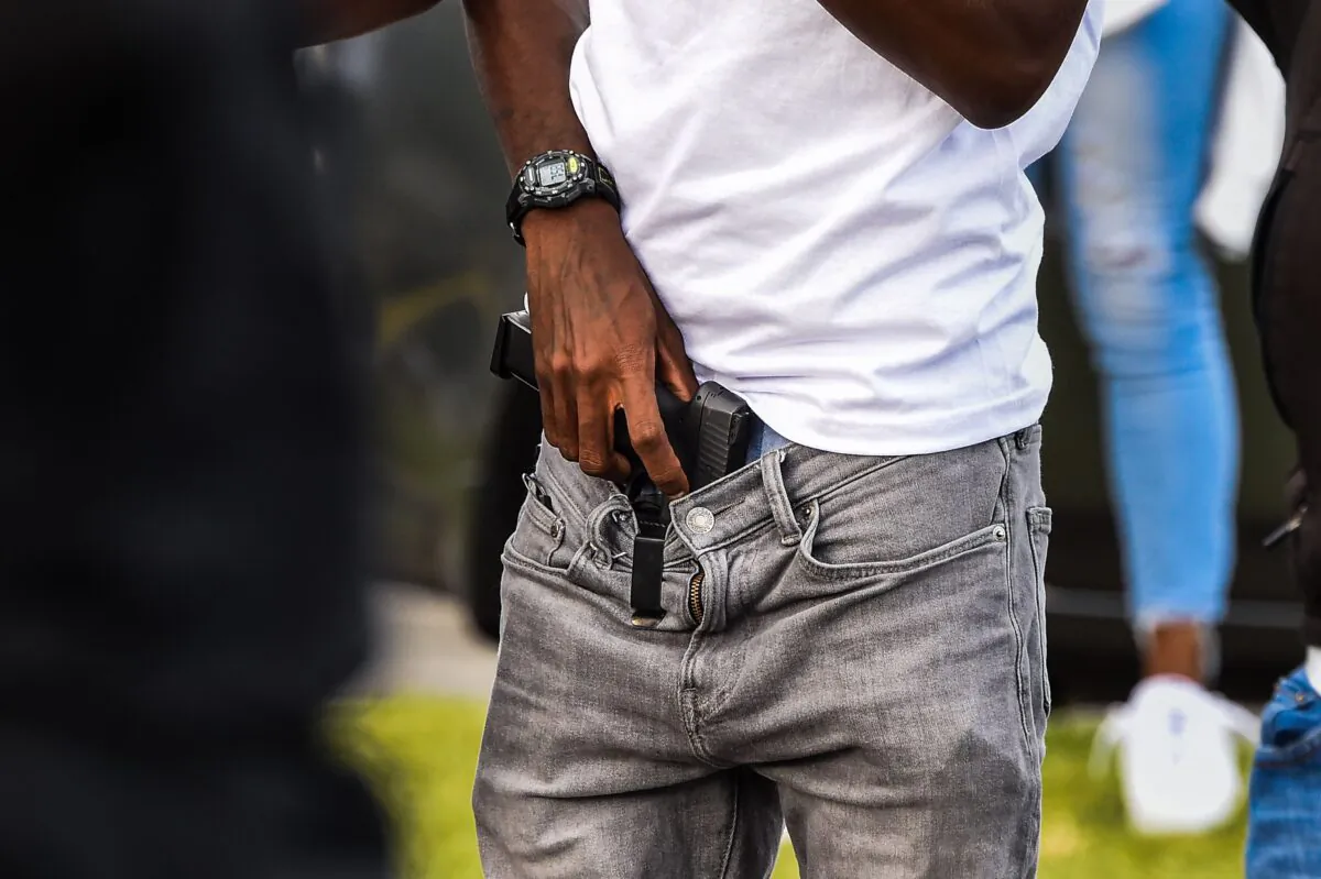 A man holds a gun as a group blocks the road next to a burned Wendy's restaurant in Atlanta, Ga., on June 16, 2020. (Chandan Khanna/AFP via Getty Images)