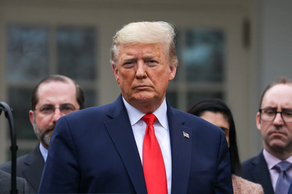 President Donald Trump, flanked by officials and business leaders, announces a national emergency with regard to the coronavirus in the White House Rose Garden in Washington on March 13, 2020. (Charlotte Cuthbertson/The Epoch Times)