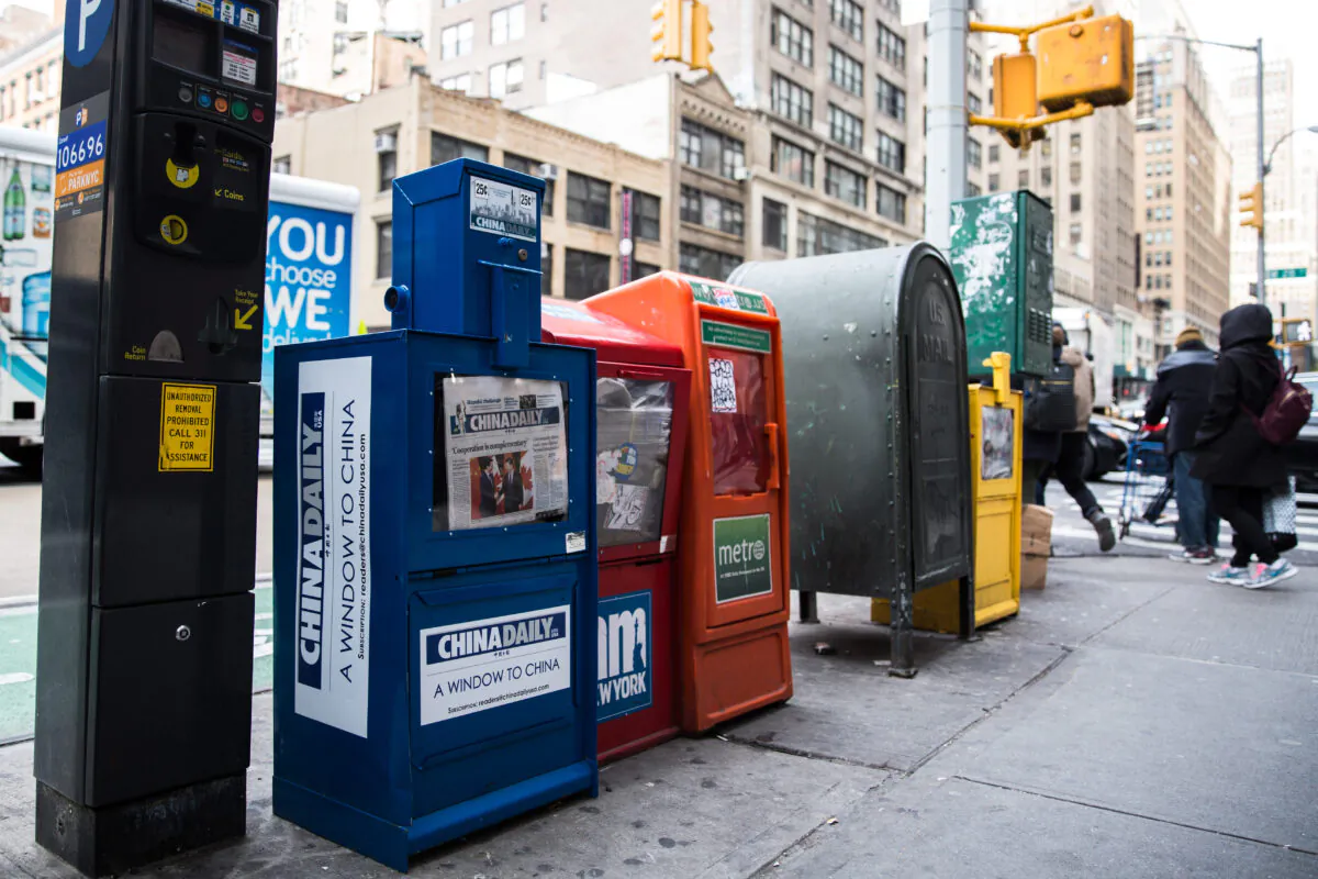 A China Daily newspaper box is with other free daily papers in Midtown Manhattan on Dec. 6, 2017. (Benjamin Chasteen/The Epoch Times)