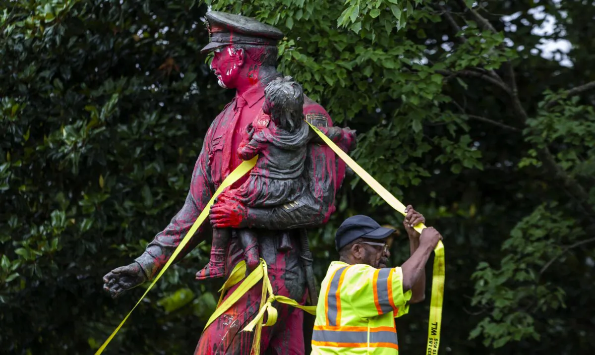 Workers remove a police memorial statue covered in red paint by protesters in Richmond, Va., on June 11, 2020. (Zach Gibson/Getty Images)