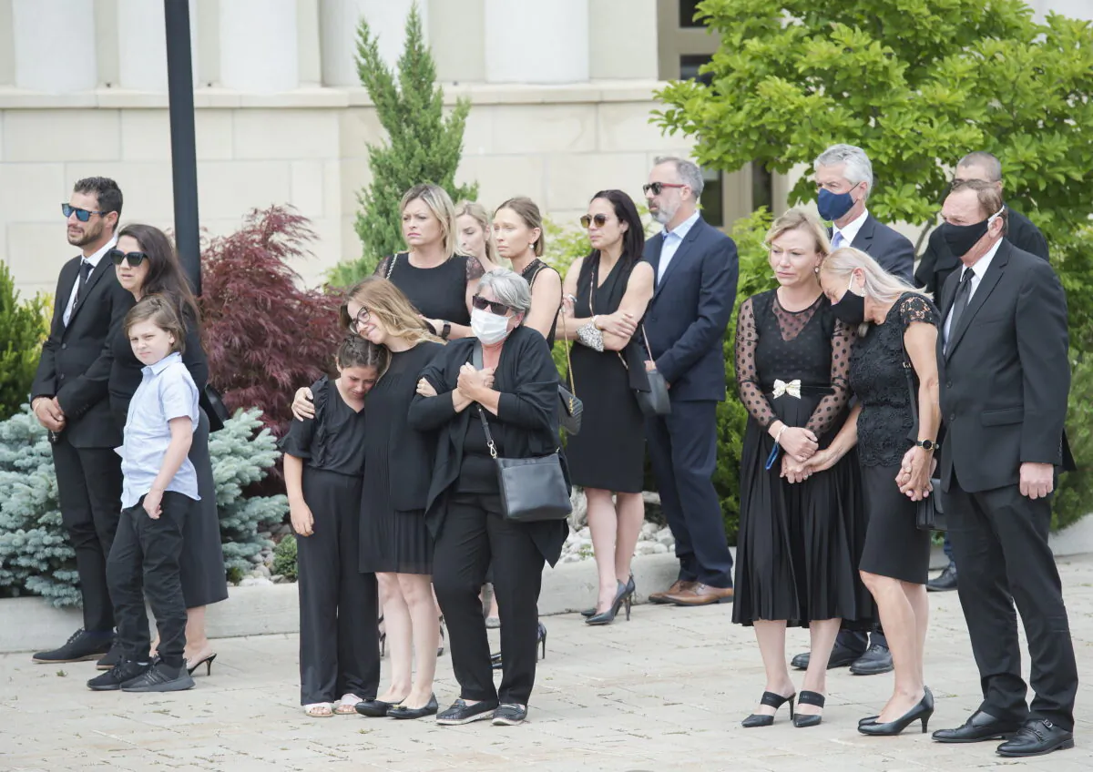 Immediate family members react as they watch the arrival of the caskets of Karolina Ciasullo and her three young daughters, six-year-old Klara Ciasullo, four-year-old Lilianna Ciasullo, and one-year-old Mila Ciasullo in Brampton, Ont., on June 25, 2020. (Nathan Denette/The Canadian Press)