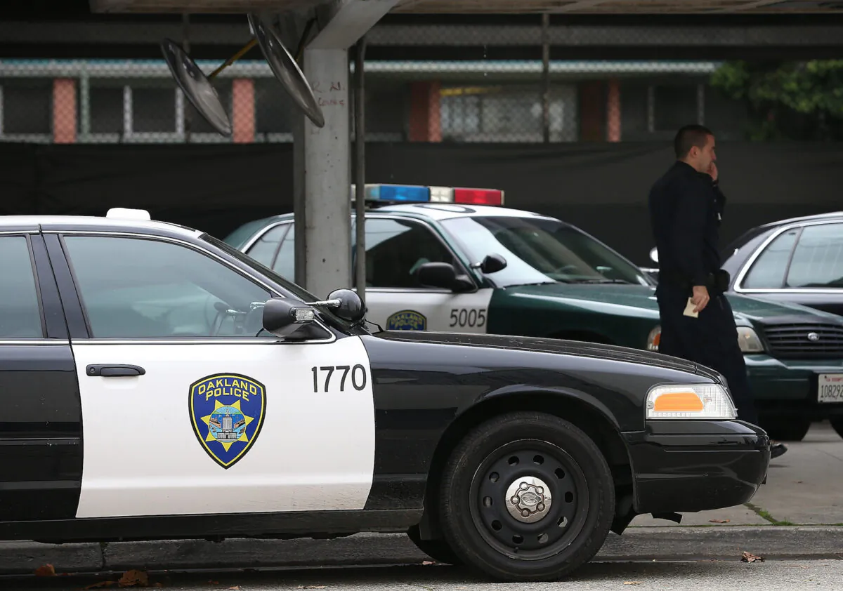 A police officer walks by patrol cars at the Oakland Police headquarters in Oakland, Calif. in a file photo. (Justin Sullivan/Getty Images)