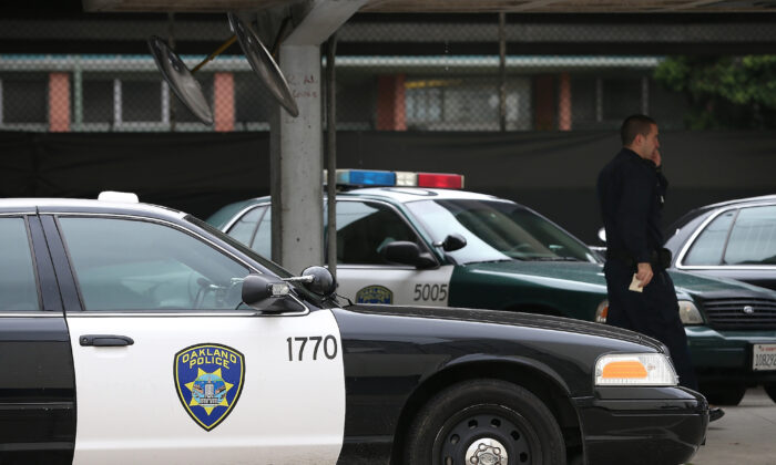 A police officer walks by patrol cars at the Oakland Police headquarters in Oakland, Calif. in a file photo. (Justin Sullivan/Getty Images)
